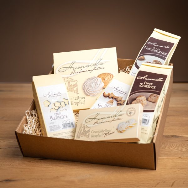 Hummel's Genießerbox: offene Geschenkbox mit Krapferl, Minis, Zwieback, Nusslebkuchen und Dinkelkeksen in Holzwolle
